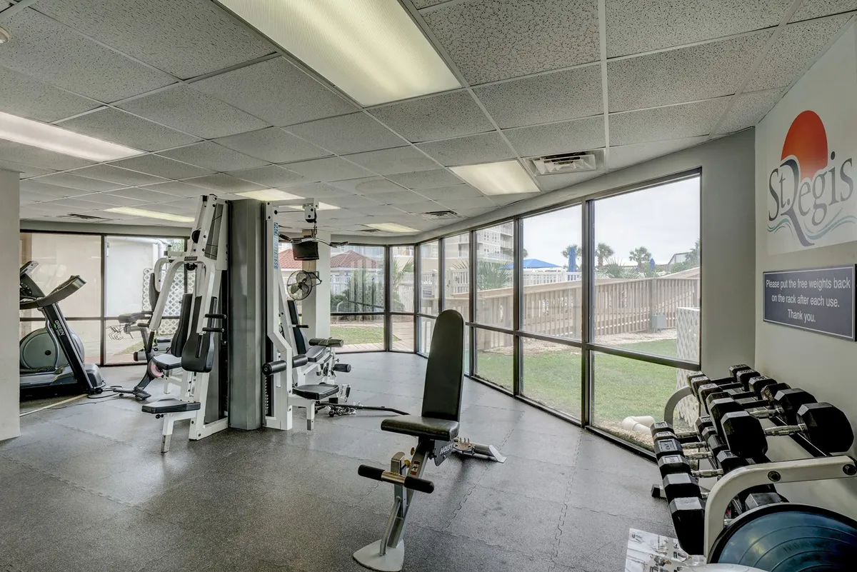 A bright and motivational fitness center filled with modern gym equipment and illuminated by large windows. The open, airy setting is ideal for personal workouts or group fitness sessions, aligning with the amenity-rich, health-conscious theme of the property.